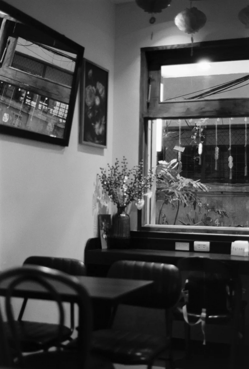 An empty cafe corner with chairs, framed pictures and paper lanterns