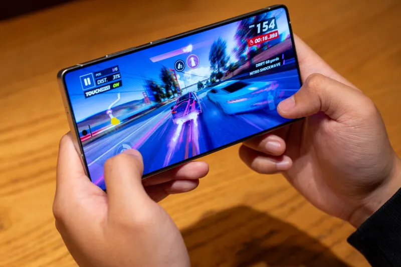 Two hands play a colorful racing game on the Galaxy S25 Ultra in landscape
